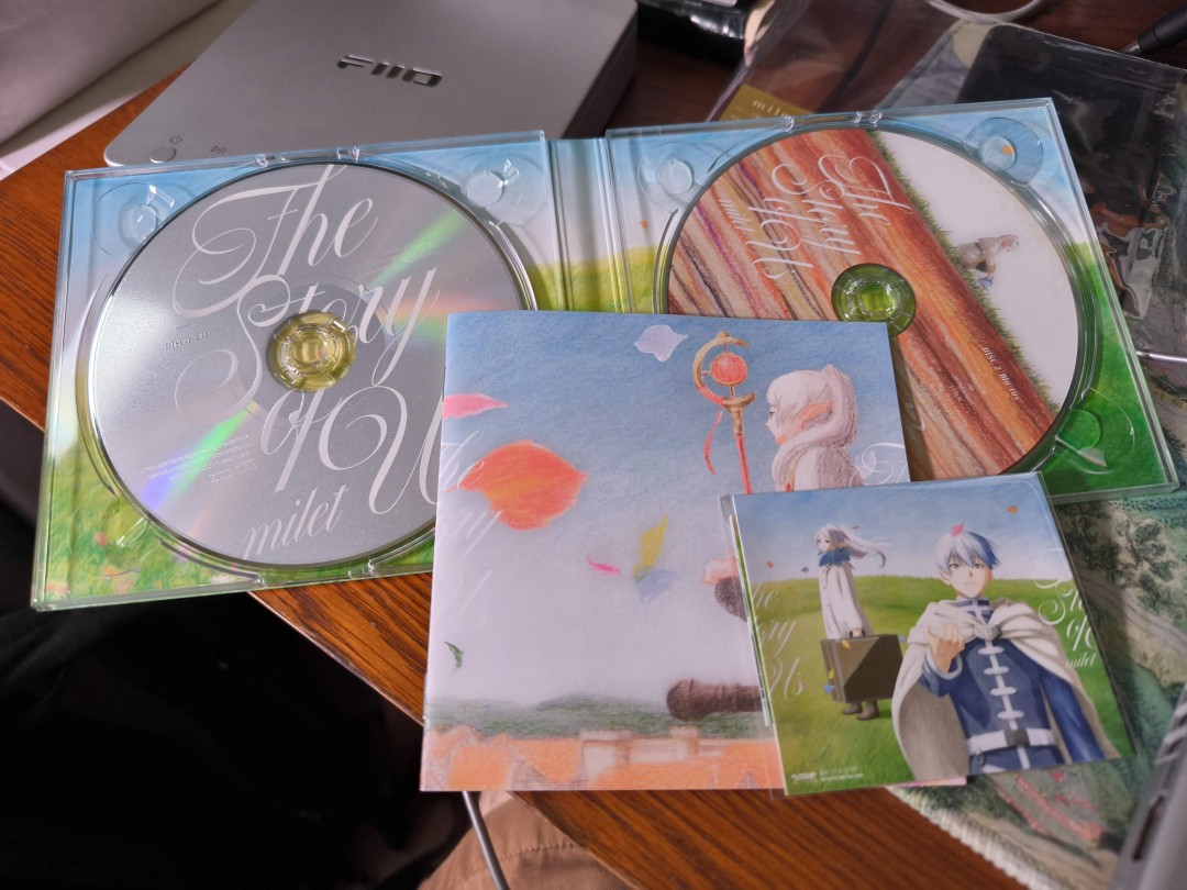 The CD case, booklet, and sticker pack